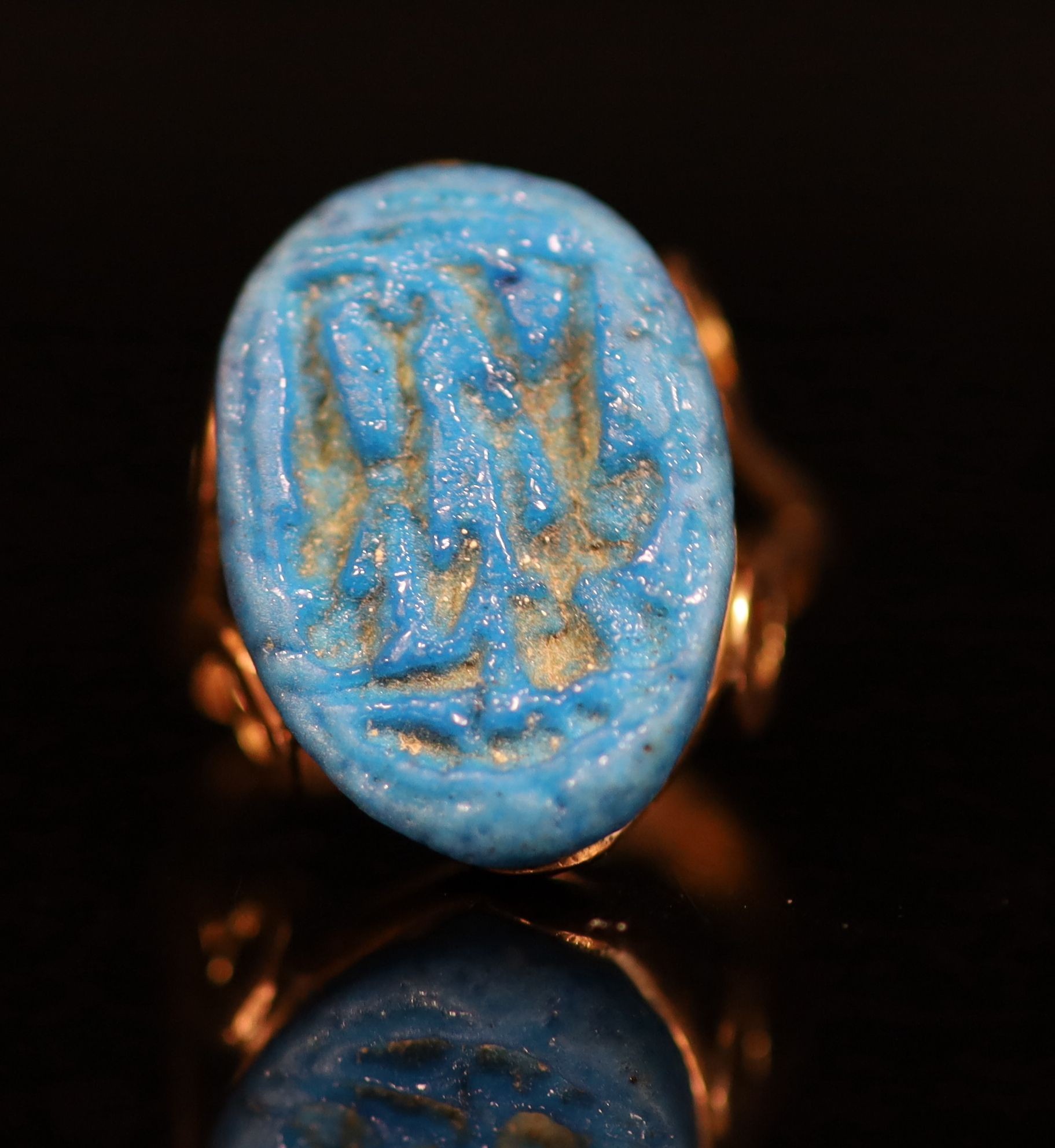 An antique gold and oval turquoise glazed intaglio set ring